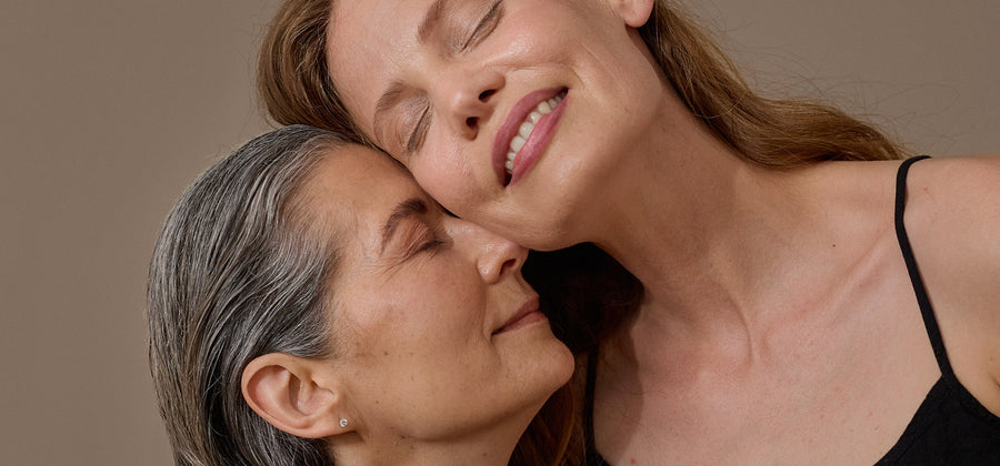 Two women touch each other with their faces