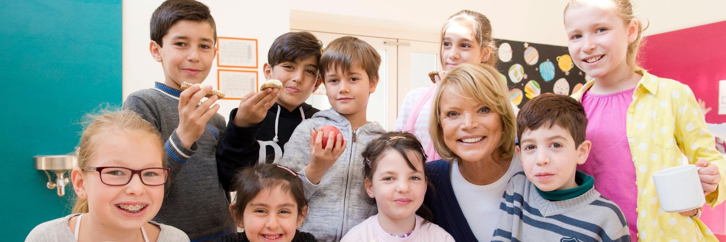 Uschi Glas smiles into the camera with nine happy children