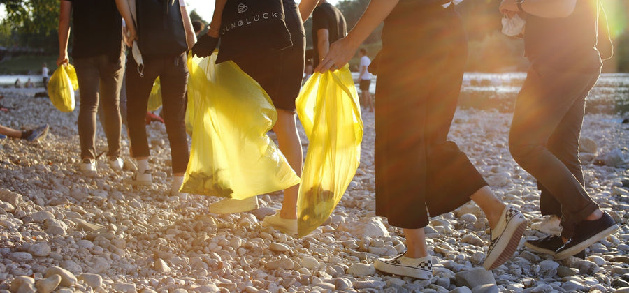 People walking on gravel and carrying garbage bags on World Clean Up Day.