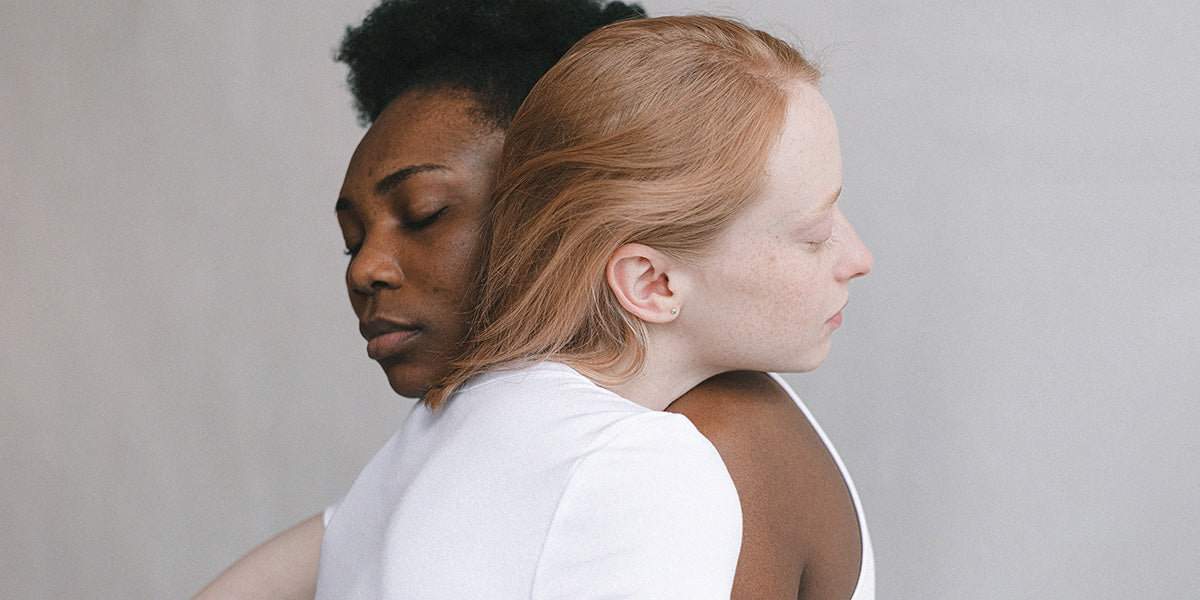 Two women embrace.