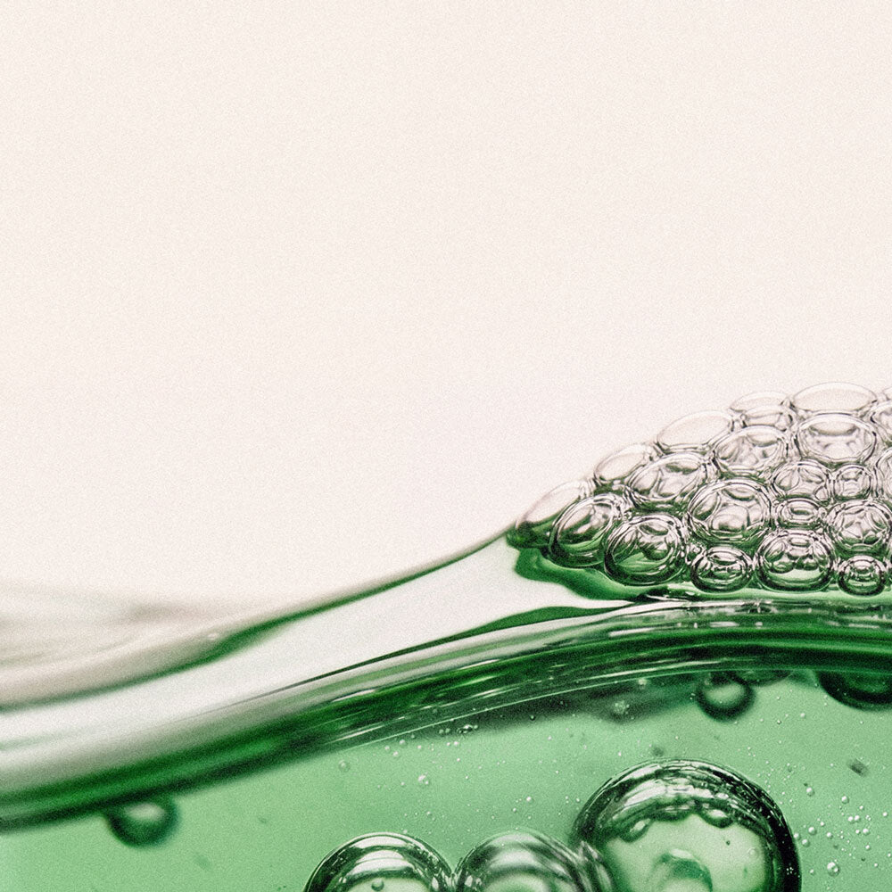 A close-up of a soft, green " gel" texture with visible bubbles, conveying a sense of lightness and freshness.