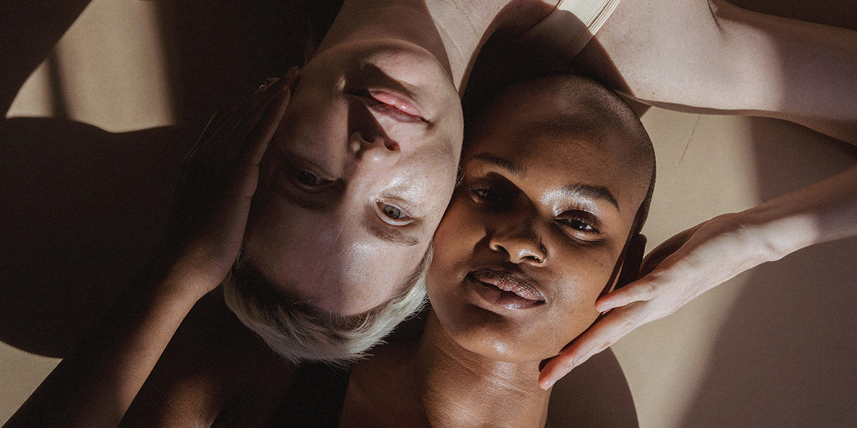 Two faces, light and dark skin, lying side by side in a familiar way